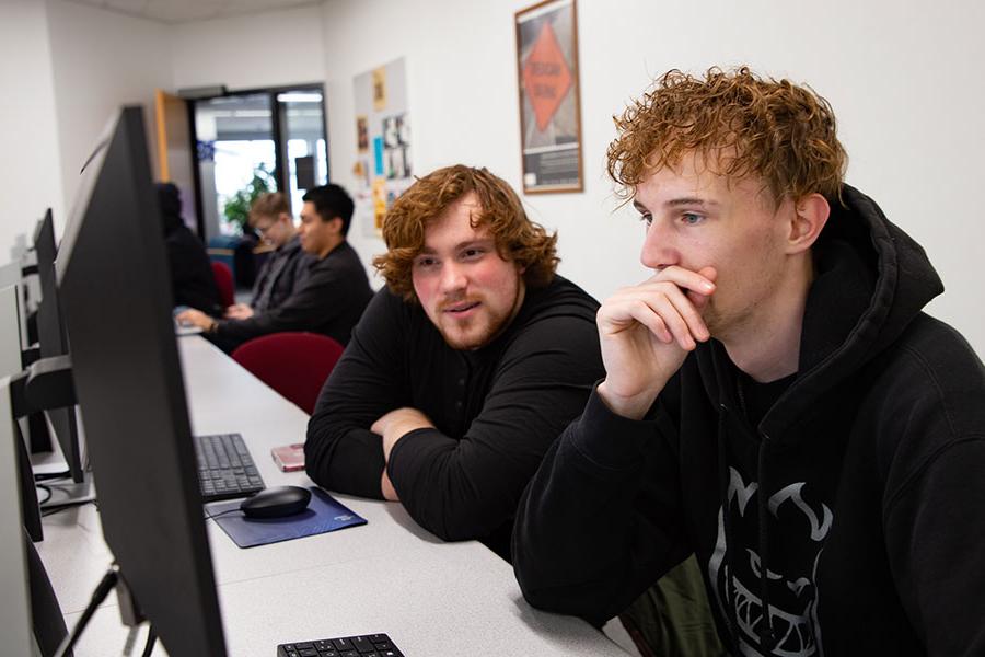 Two San Juan College students sit in front of a computer